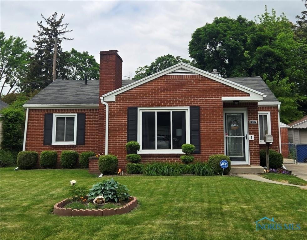 2352 Sherwood Ave, Toledo, OH 43614 - view of front of home with brick siding, a chimney, and a front lawn