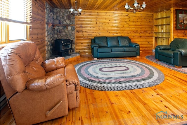555 Race St, Clyde, OH 43410 - living area featuring a chandelier, a wood stove, wood ceiling, hardwood / wood-style flooring, and log walls