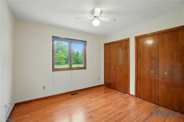 4820 Olde Meadow Ln, Sylvania, OH 43560 - unfurnished bedroom with two closets, light wood-type flooring, baseboards, and ceiling fan