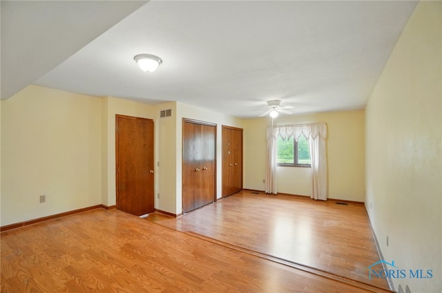 4820 Olde Meadow Ln, Sylvania, OH 43560 - unfurnished bedroom with light wood-type flooring, multiple closets, baseboards, and a ceiling fan