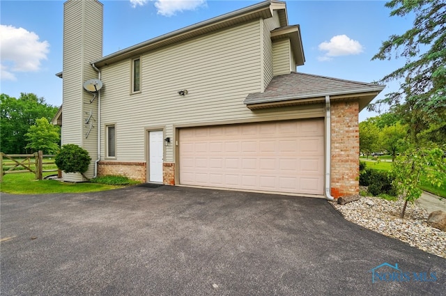 4820 Olde Meadow Ln, Sylvania, OH 43560 - view of side of home with brick siding, a chimney, and driveway