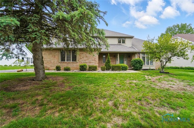 4820 Olde Meadow Ln, Sylvania, OH 43560 - traditional-style house with a front yard, a shingled roof, and brick siding