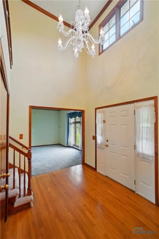 4820 Olde Meadow Ln, Sylvania, OH 43560 - foyer entrance with a chandelier, a towering ceiling, wood finished floors, crown molding, and baseboards