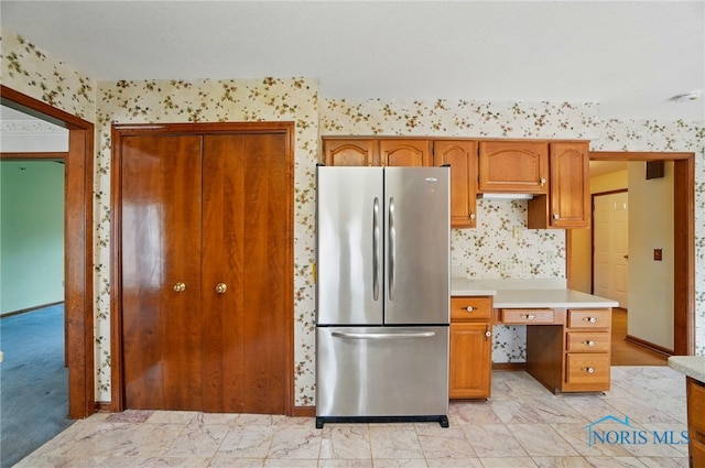 4820 Olde Meadow Ln, Sylvania, OH 43560 - kitchen featuring freestanding refrigerator, light marble finish flooring, light countertops, wallpapered walls, and brown cabinets