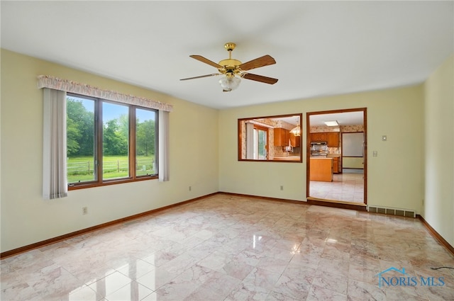 4820 Olde Meadow Ln, Sylvania, OH 43560 - empty room with light marble finish floors, a ceiling fan, and baseboards