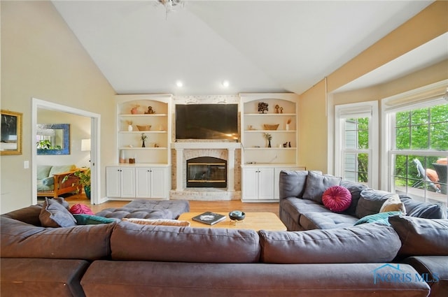 8420 Willow Glen Ct, Holland, OH 43528 - living room featuring lofted ceiling, light wood-style flooring, a fireplace, and built in features