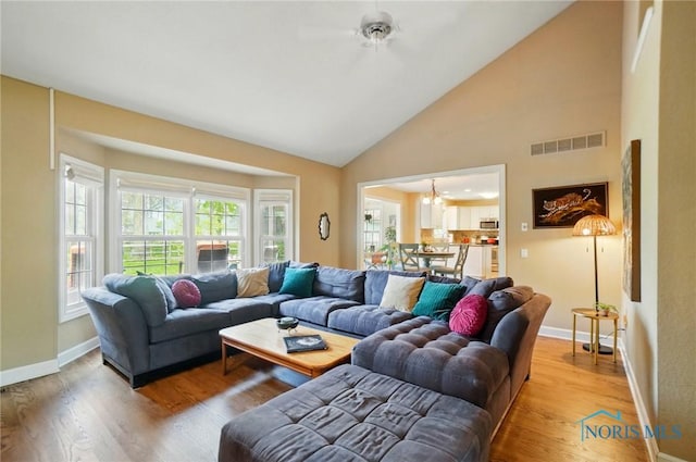 8420 Willow Glen Ct, Holland, OH 43528 - living room with wood finished floors, baseboards, high vaulted ceiling, and a chandelier