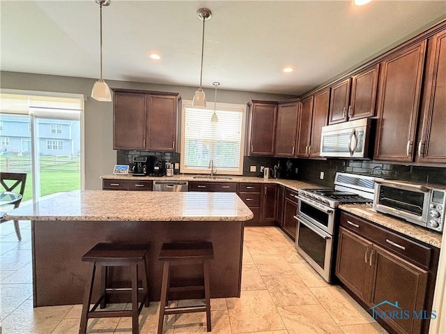 3244 Chasenwood Way, Perrysburg, OH 43551 - kitchen featuring stainless steel appliances, a sink, backsplash, a kitchen island, and dark brown cabinets