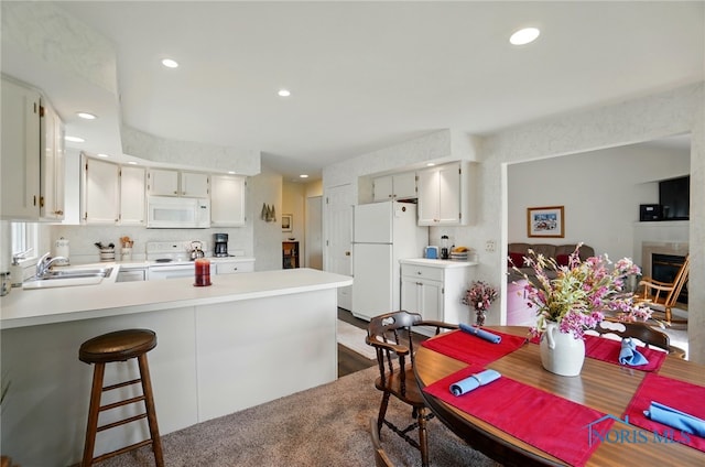 5733 Brook Cliffe Rd, Toledo, OH 43614 - kitchen featuring white appliances, a peninsula, a sink, recessed lighting, and light countertops