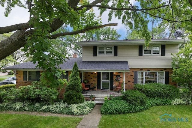 633 Hillcrest Ave, Findlay, OH 45840 - view of front facade featuring brick siding, a porch, and a chimney