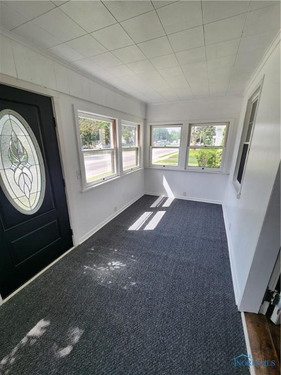 815 S Blanchard St, Findlay, OH 45840 - foyer with crown molding, dark colored carpet, and baseboards