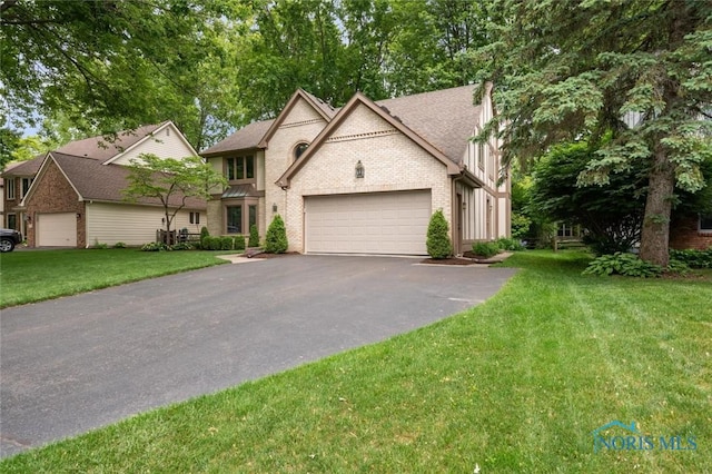 2426 Gibley Park Rd, Toledo, OH 43617 - view of front of property featuring an attached garage, asphalt driveway, a front lawn, and brick siding