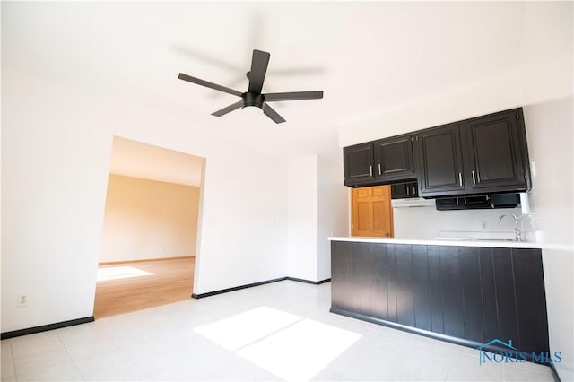 1621 Acorn Dr, Toledo, OH 43615 - kitchen with dark cabinetry, a ceiling fan, light countertops, a peninsula, and black microwave