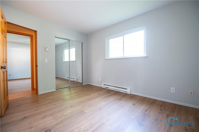 1621 Acorn Dr, Toledo, OH 43615 - unfurnished bedroom featuring baseboard heating, light wood-style floors, and a closet