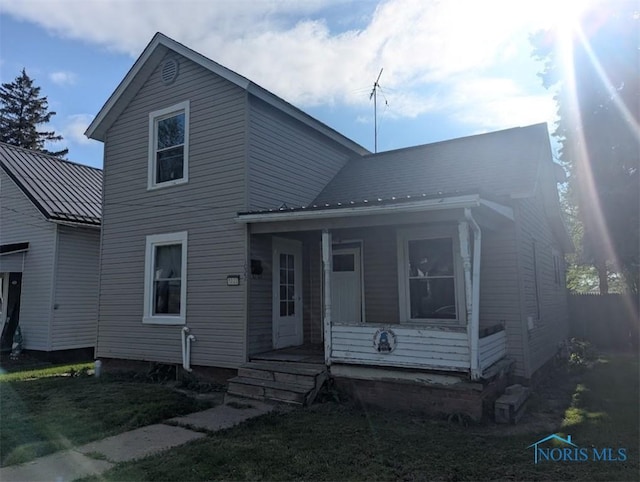 1022 Dodd St, Napoleon, OH 43545 - view of front of home with covered porch, a standing seam roof, metal roof, and a front lawn