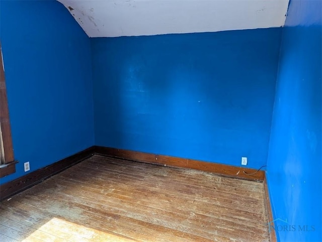 1022 Dodd St, Napoleon, OH 43545 - spare room featuring hardwood / wood-style floors, lofted ceiling, and baseboards