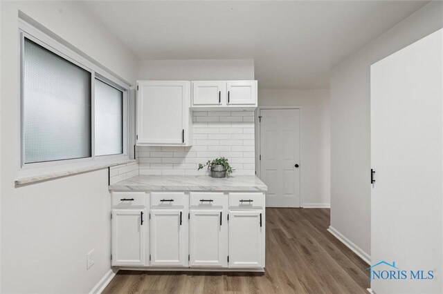 4801 Estero Pl, Toledo, OH 43623 - kitchen featuring white cabinetry, wood finished floors, and backsplash