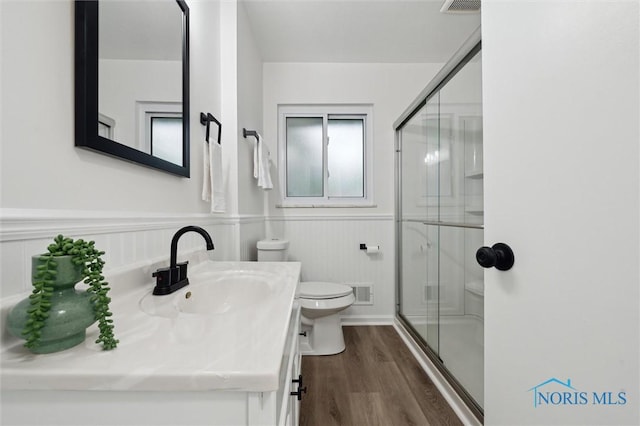 4801 Estero Pl, Toledo, OH 43623 - full bath featuring toilet, a stall shower, vanity, wood finished floors, and a wainscoted wall