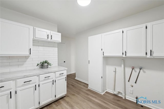 4801 Estero Pl, Toledo, OH 43623 - kitchen with white cabinetry, decorative backsplash, light wood-style flooring, and baseboards