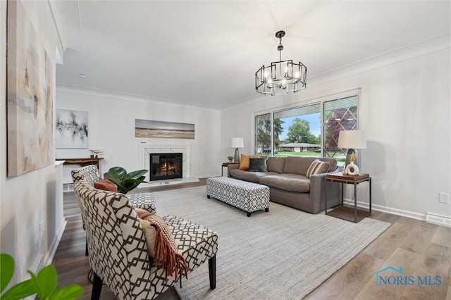 4801 Estero Pl, Toledo, OH 43623 - living room featuring wood finished floors, baseboards, ornamental molding, a glass covered fireplace, and a chandelier