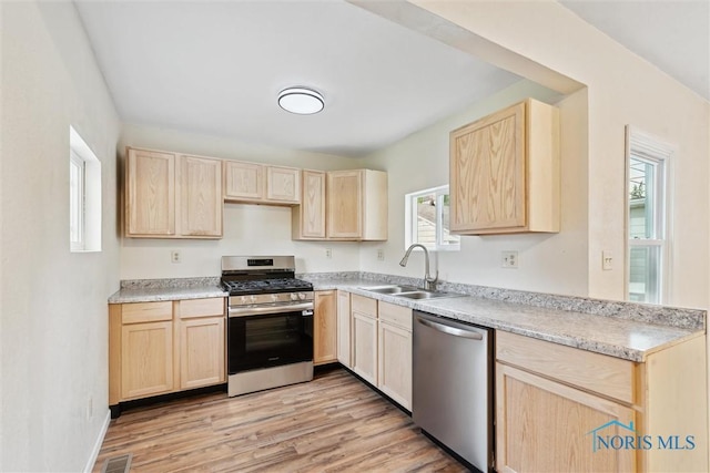 3409 Kirby Pl, Toledo, OH 43608 - kitchen with light brown cabinetry, appliances with stainless steel finishes, and healthy amount of natural light