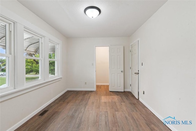 3409 Kirby Pl, Toledo, OH 43608 - spare room with wood finished floors, healthy amount of natural light, and baseboards