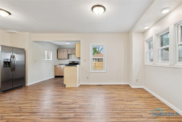 3409 Kirby Pl, Toledo, OH 43608 - kitchen featuring stainless steel appliances, light wood-type flooring, baseboards, light brown cabinetry, and a textured ceiling