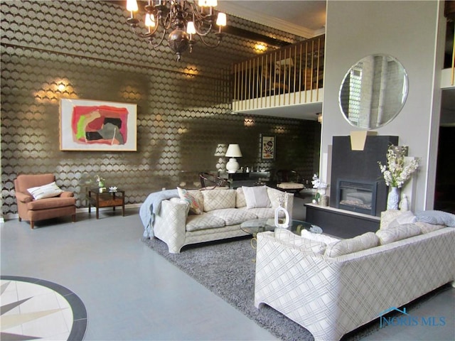 4343 W Bancroft St Unit 2D, Toledo, OH 43615 - living room featuring a chandelier, a glass covered fireplace, a high ceiling, and ornamental molding