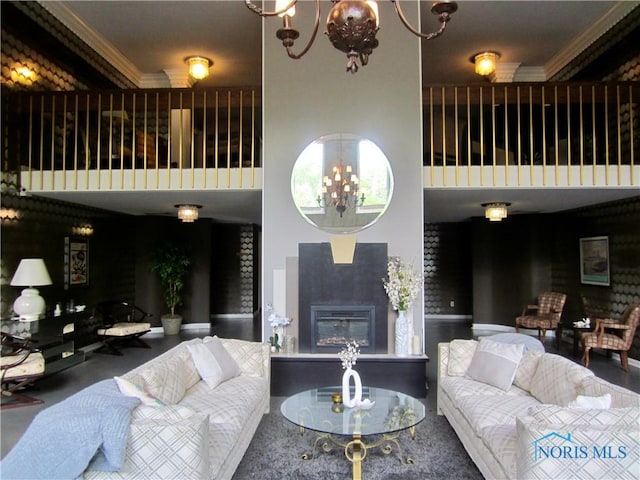 4343 W Bancroft St Unit 2D, Toledo, OH 43615 - living room featuring crown molding, a glass covered fireplace, a towering ceiling, and a chandelier