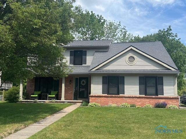 3722 Wild Pheasant Ln, Sylvania, OH 43560 - view of front of home with brick siding, a front lawn, and roof with shingles