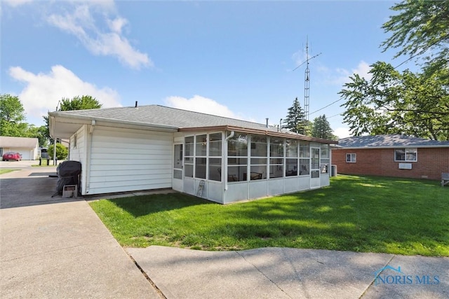 955 Westmont Ave, Napoleon, OH 43545 - rear view of house featuring a sunroom and a yard