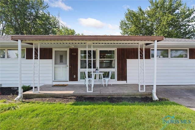 955 Westmont Ave, Napoleon, OH 43545 - ranch-style house with a porch, a front lawn, driveway, and roof with shingles