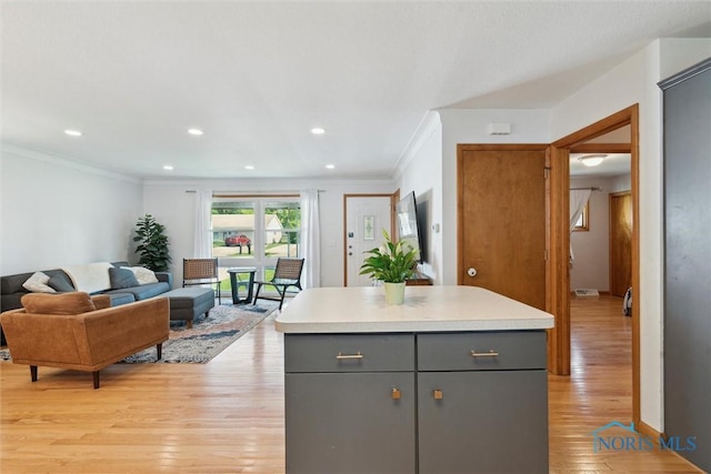 955 Westmont Ave, Napoleon, OH 43545 - kitchen with gray cabinetry, ornamental molding, light wood-type flooring, light countertops, and open floor plan