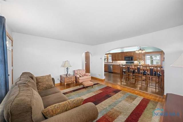 15819 County Road D, Wauseon, OH 43567 - living area with arched walkways, light wood finished floors, and a chandelier