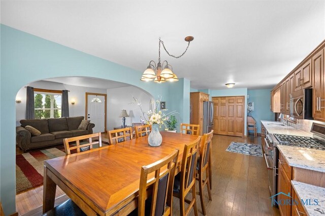 15819 County Road D, Wauseon, OH 43567 - dining space with arched walkways, dark wood-type flooring, and a chandelier