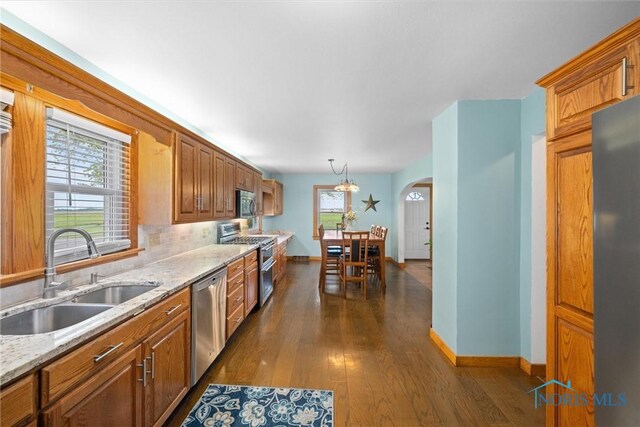 15819 County Road D, Wauseon, OH 43567 - kitchen featuring appliances with stainless steel finishes, a sink, arched walkways, and baseboards
