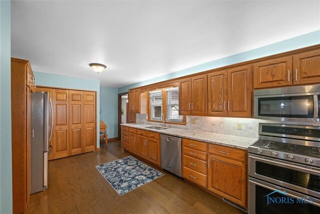 15819 County Road D, Wauseon, OH 43567 - kitchen featuring appliances with stainless steel finishes, a sink, dark wood-type flooring, and brown cabinetry