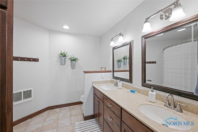 15819 County Road D, Wauseon, OH 43567 - full bath featuring double vanity, toilet, baseboards, recessed lighting, and tile patterned floors