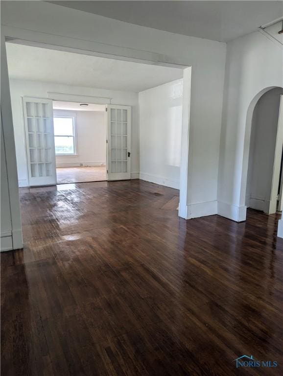 137 N 8th St, Upper Sandusky, OH 43351 - spare room with arched walkways, dark wood-type flooring, and baseboards