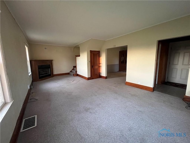 11157 State Route 500, Paulding, OH 45879 - unfurnished living room featuring baseboards, a fireplace, ornamental molding, stairway, and carpet floors