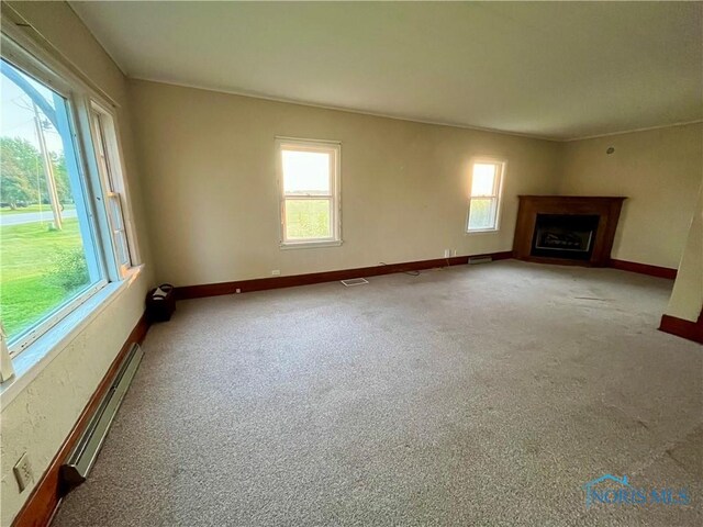 11157 State Route 500, Paulding, OH 45879 - unfurnished living room featuring a fireplace with flush hearth, a baseboard radiator, baseboards, and carpet