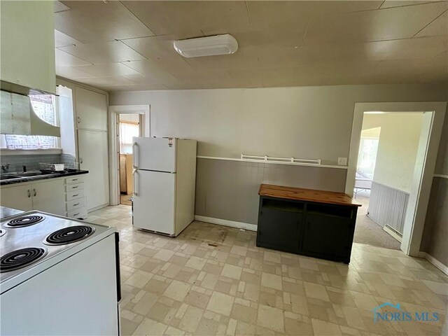 11157 State Route 500, Paulding, OH 45879 - kitchen featuring white appliances, plenty of natural light, white cabinetry, and radiator