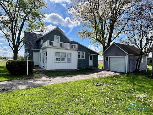 11157 State Route 500, Paulding, OH 45879 - view of front of property featuring a balcony, an outdoor structure, a detached garage, asphalt driveway, and a front lawn