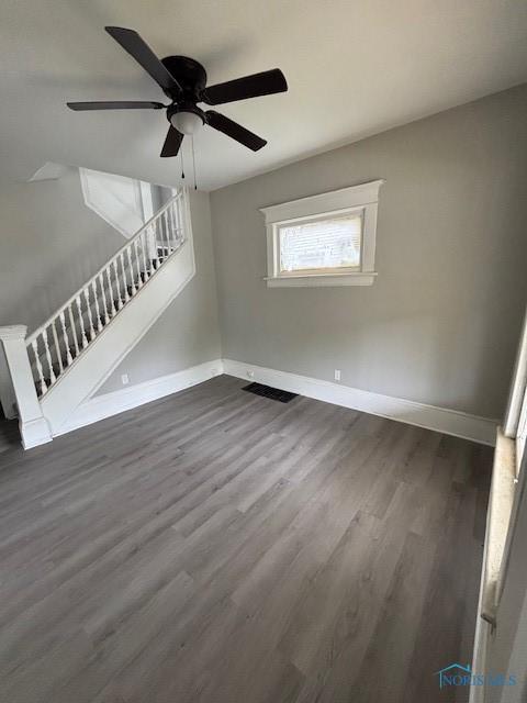 3239 Cherry St, Toledo, OH 43608 - unfurnished living room with baseboards, stairs, dark wood-style flooring, and ceiling fan