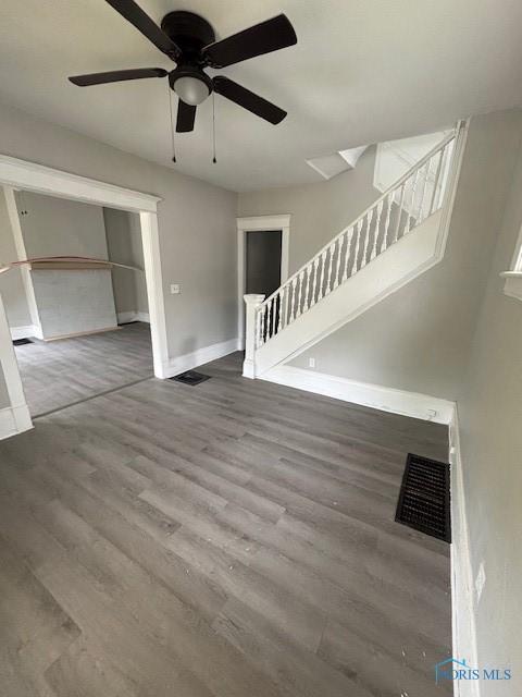 3239 Cherry St, Toledo, OH 43608 - unfurnished living room with baseboards, wood finished floors, a ceiling fan, and stairs