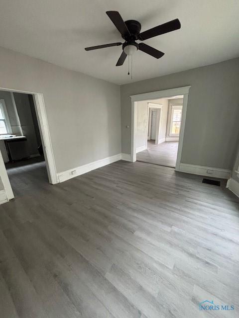 3239 Cherry St, Toledo, OH 43608 - empty room featuring baseboards, dark wood-type flooring, and healthy amount of natural light