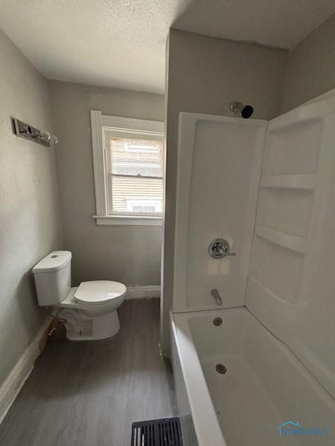 3239 Cherry St, Toledo, OH 43608 - bathroom with toilet, wood finished floors, shower / tub combination, and baseboards