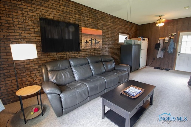1133 Cuba St, Toledo, OH 43615 - living area featuring light carpet, ceiling fan, and brick wall