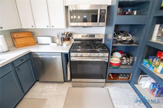 1133 Cuba St, Toledo, OH 43615 - kitchen featuring stainless steel appliances, light countertops, white cabinetry, and blue cabinets