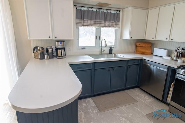 1133 Cuba St, Toledo, OH 43615 - kitchen with appliances with stainless steel finishes, a sink, a peninsula, light countertops, and white cabinets